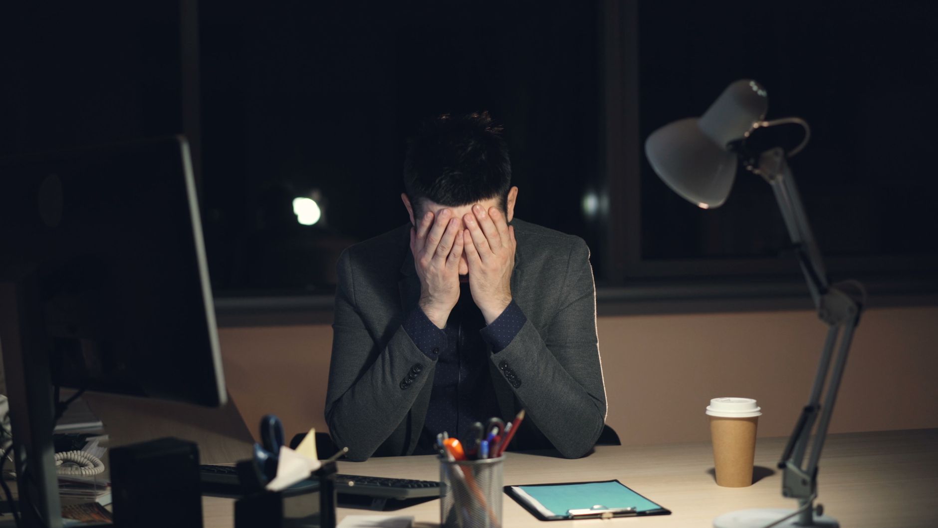 hombre agotado trabajando de noche en la oficina