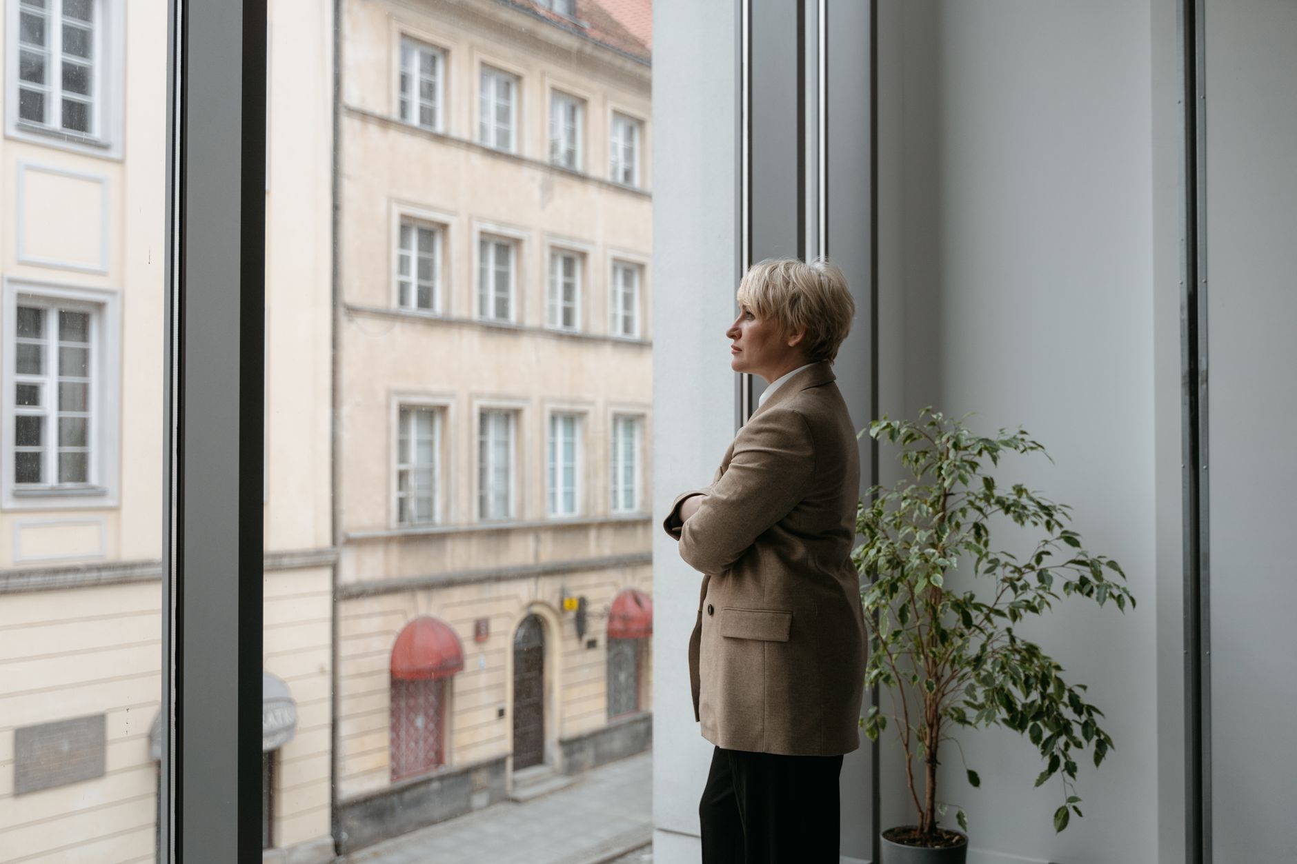 Mujer profesional pensativa mirando por la ventana de una oficina